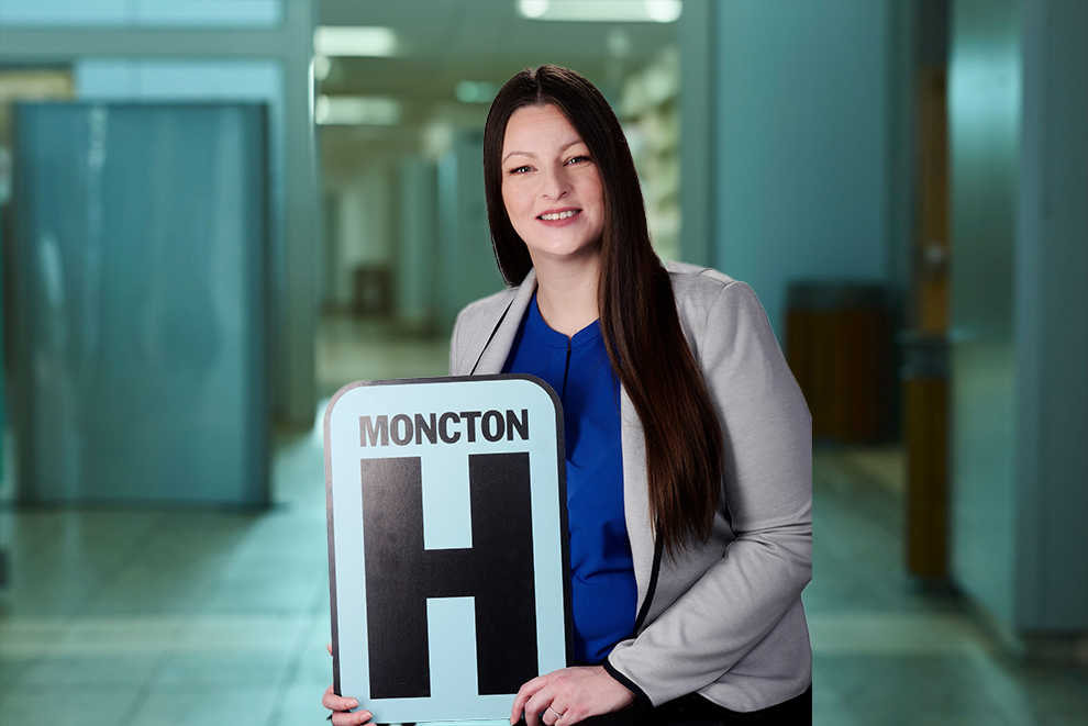 Angela Landry Headshot Holding Moncton H logo