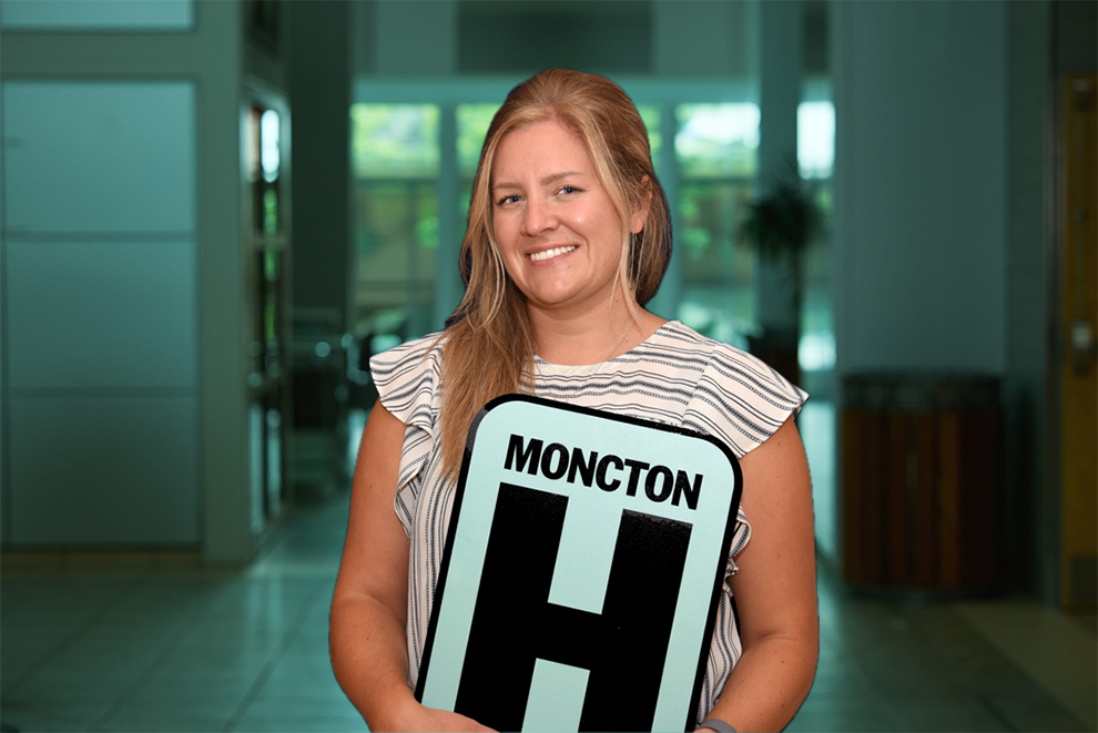 Annick Ouellette Headshot Holding Moncton H logo