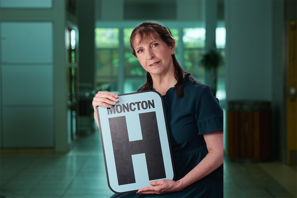 Jackie Headshot Holding Moncton H logo