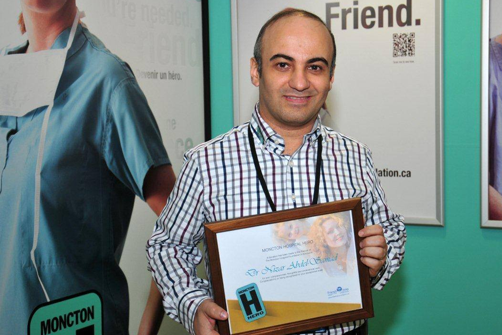 Dr. Nizar Abdel Samad holding a frame with his Hospital Hero Certificate