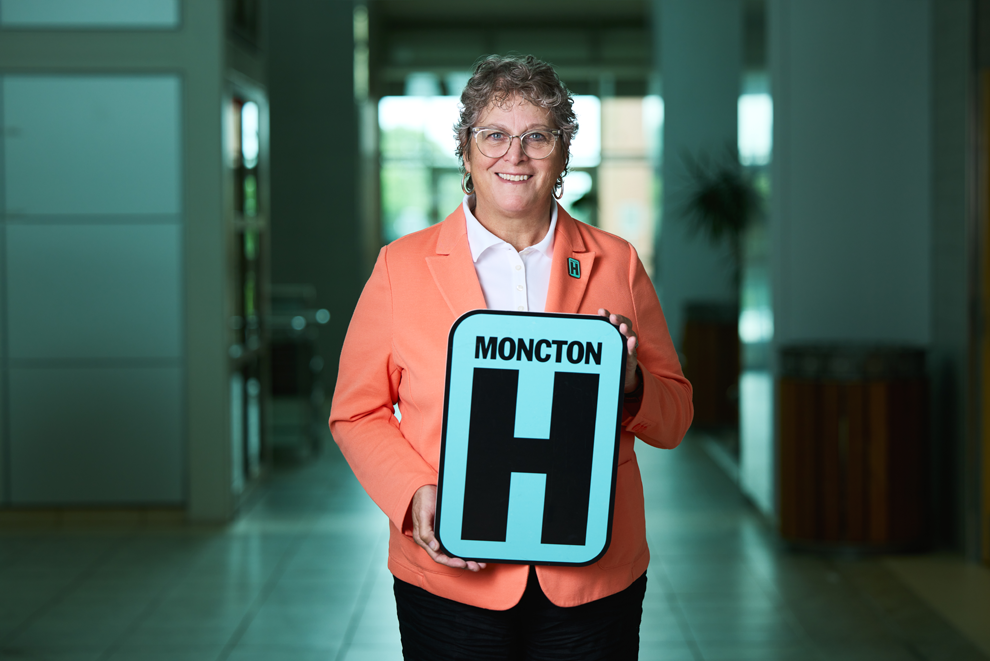 Jackie Headshot Holding Moncton H logo