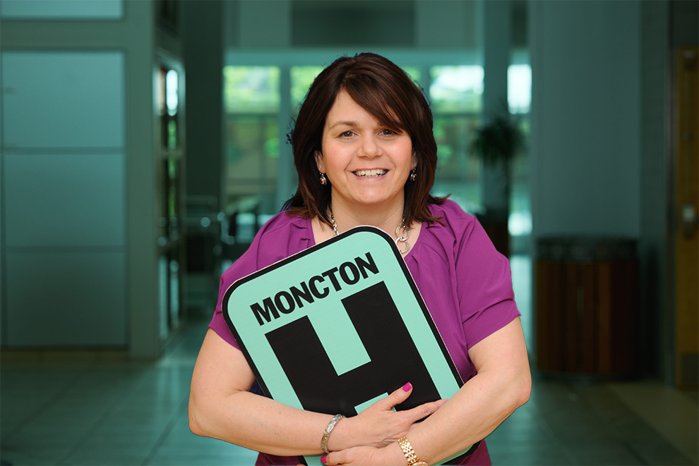 Janice  Headshot Holding Moncton H logo