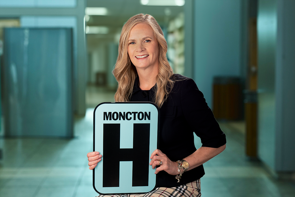 Katherine Headshot Holding Moncton H logo
