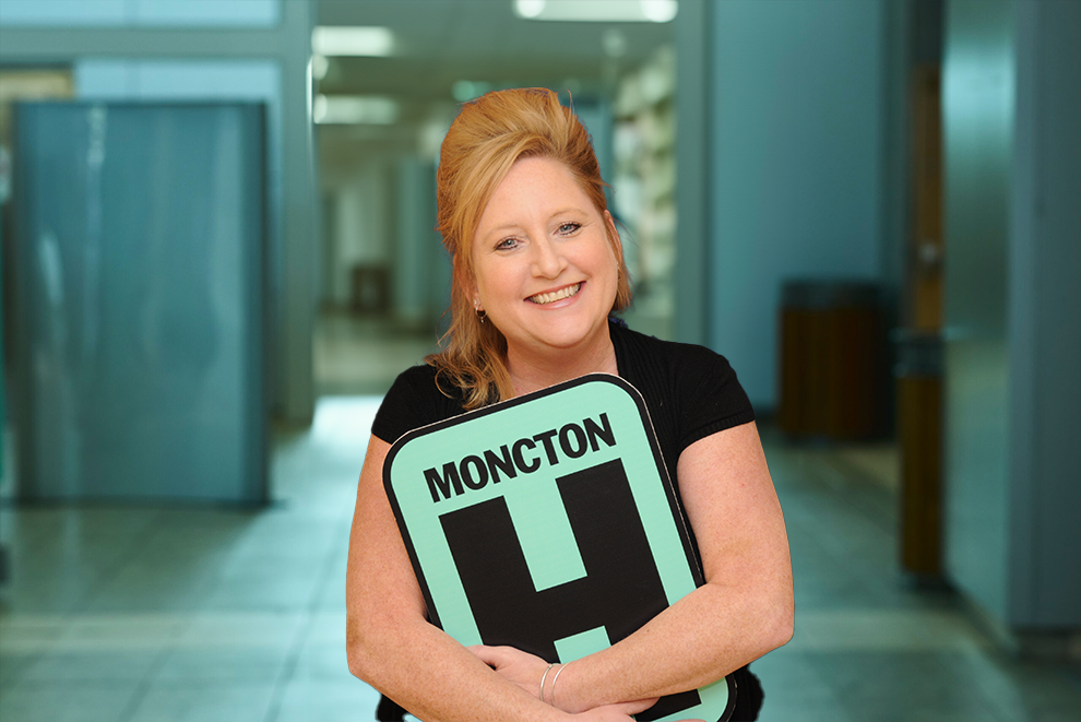 Marianne Headshot Holding Moncton H logo