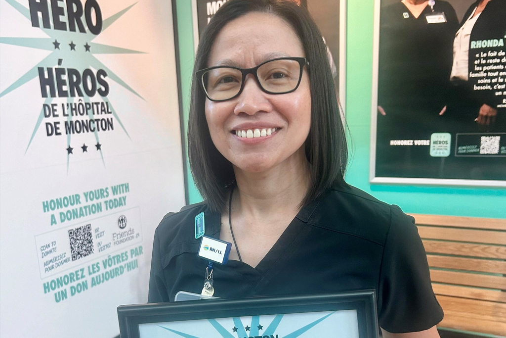Rose Ehimplar Gizza, RN Holding her Hospital Hero Award