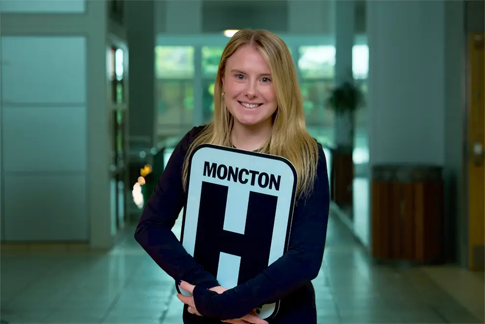 Allison Henderson Holding H Sign and Smiling at camera