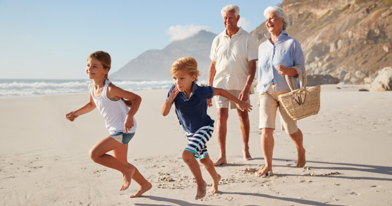 Grandparents and grand kids walking on beach