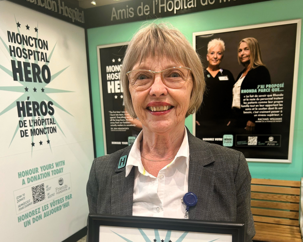 Lori Vrensen holding a Hospital Hero Plaque